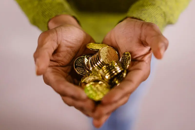 Gold coins in hands showing quality inspection