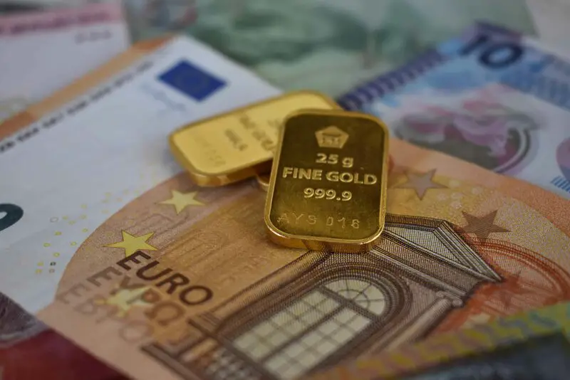 Physical gold bars on currency representing investment comparison
